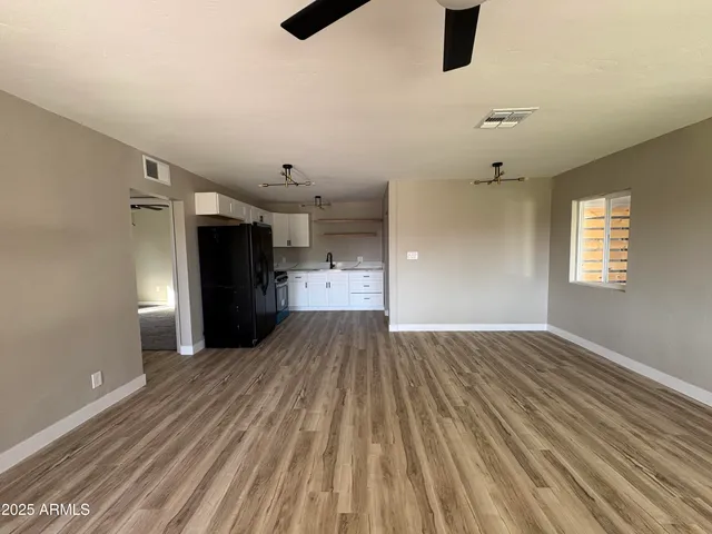 wooden floor in an empty room with a kitchen