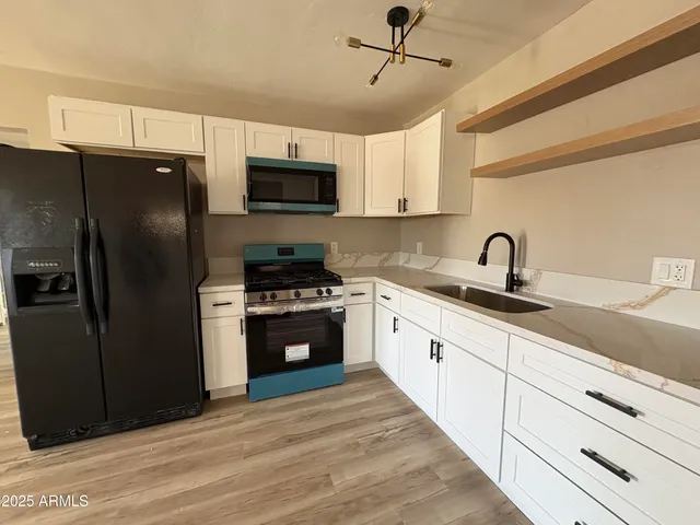a kitchen with stainless steel appliances a refrigerator sink and microwave