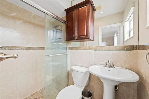 a bathroom with a sink a toilet and mirror