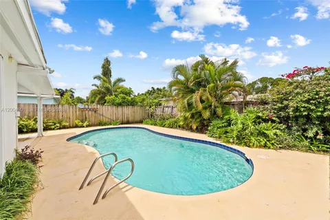 a view of a swimming pool with a patio and a yard