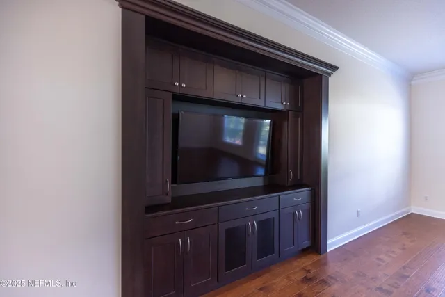 a living room with a wooden floor and a microwave