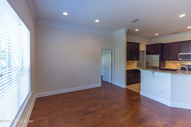 a view of kitchen with kitchen island microwave and wooden floor