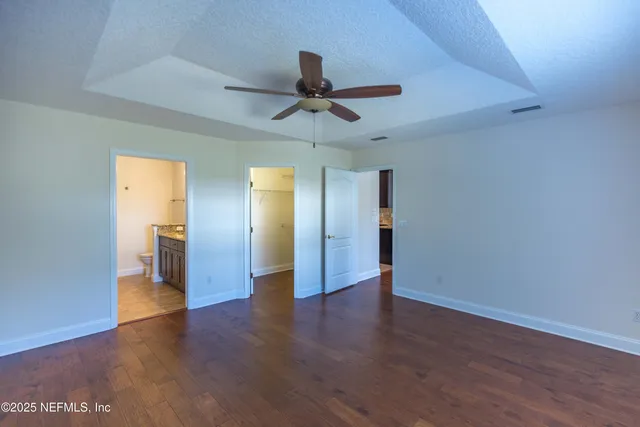 a view of a livingroom with wooden floor and a ceiling fan