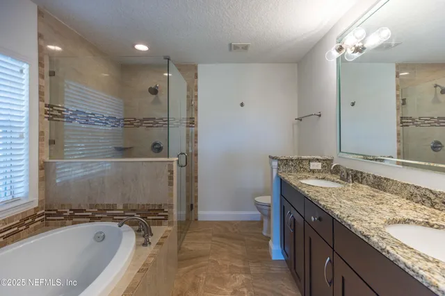 a spacious bathroom with a granite countertop tub sink and mirror