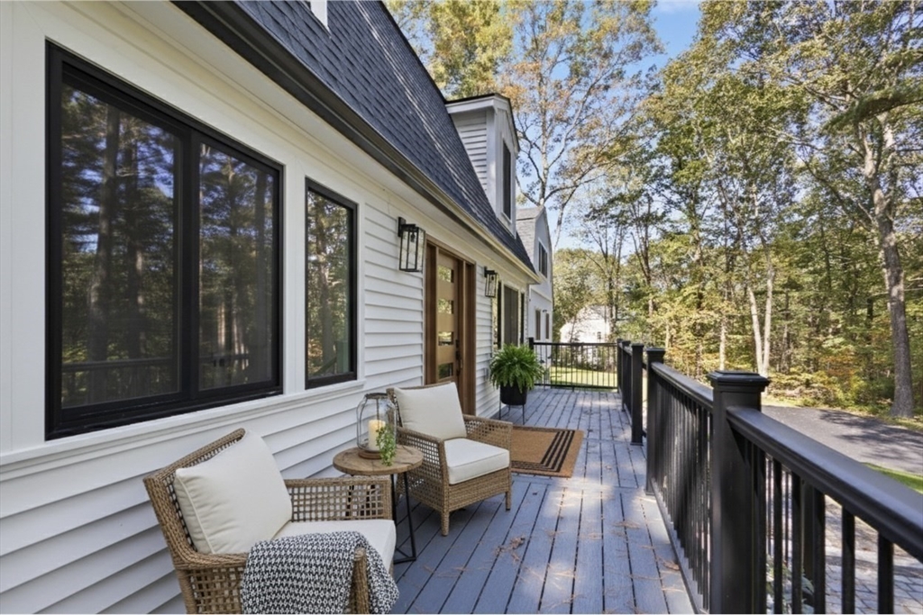 a view of a patio with couches table and chairs and wooden floor