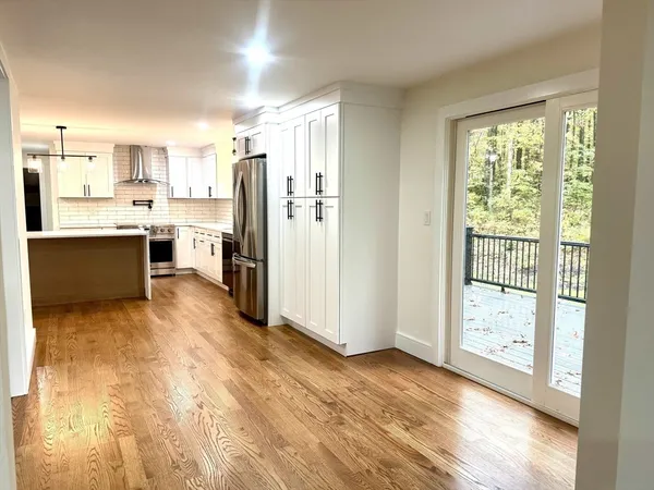 a view of kitchen with stainless steel appliances granite countertop a refrigerator stove top oven and sink