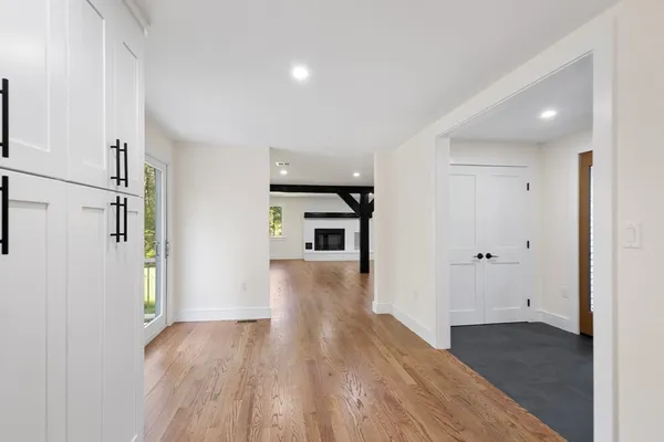 a view of a hallway with wooden floor and a bathroom