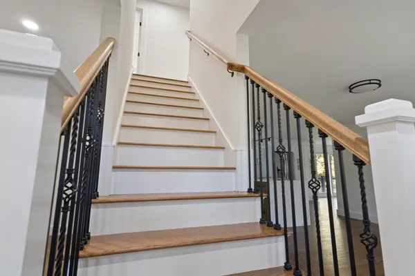 a view of staircase with wooden floor and white walls