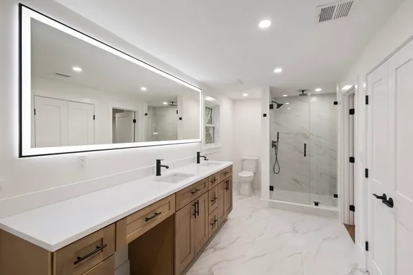 a spacious bathroom with a double vanity sink mirror double and shower