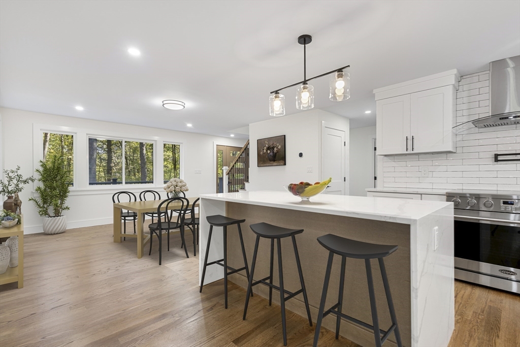 241 Prospect Street Franklin, MA 02038 - Photo 4 of 42 a kitchen with stainless steel appliances granite countertop wooden floor dining table and chairs