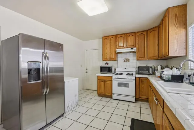 a kitchen with a refrigerator sink and cabinets
