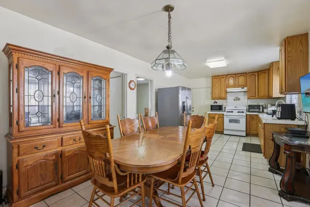 a dining room with furniture a chandelier and kitchen view