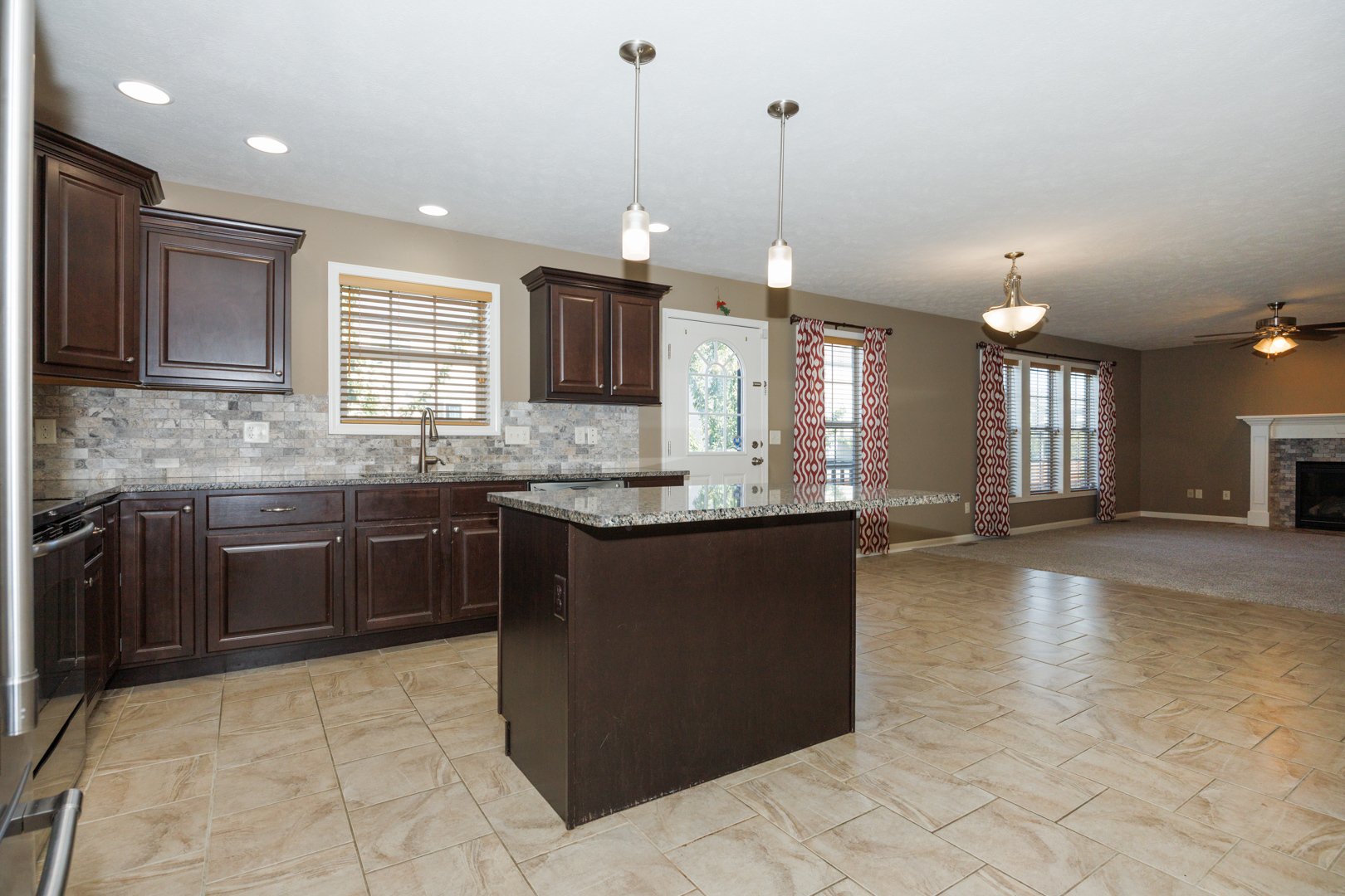1714 Flagstone Drive Normal, IL 61761 - Photo 23 of 61 a kitchen with kitchen island granite countertop a stove a sink a counter space and cabinets