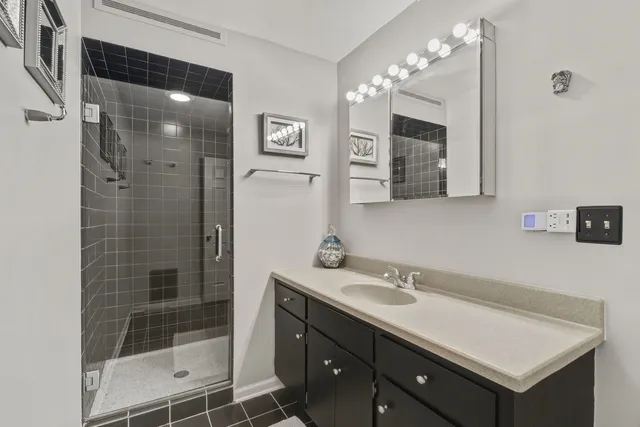 a bathroom with a shower sink vanity and mirror