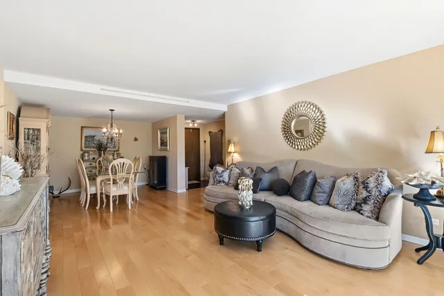 a living room with furniture and a large mirror with wooden floor