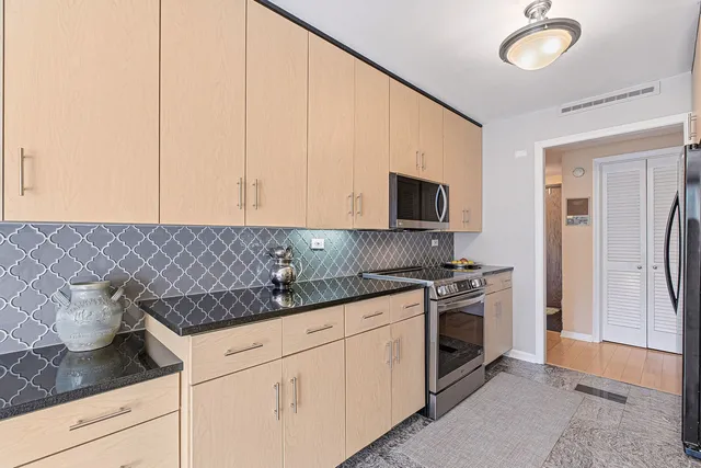 a kitchen with stainless steel appliances granite countertop a stove a sink and a microwave
