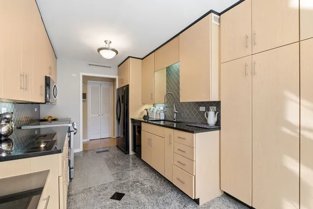 a kitchen with stainless steel appliances a stove a sink and a refrigerator