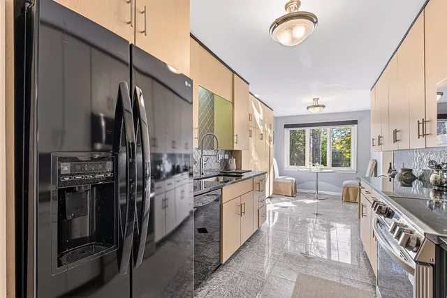 a kitchen with stainless steel appliances granite countertop a refrigerator a stove and a sink