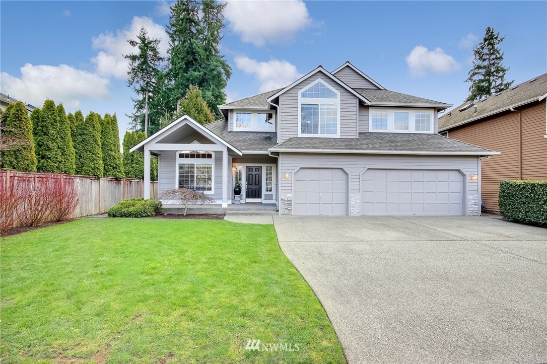 a front view of a house with a garden and yard