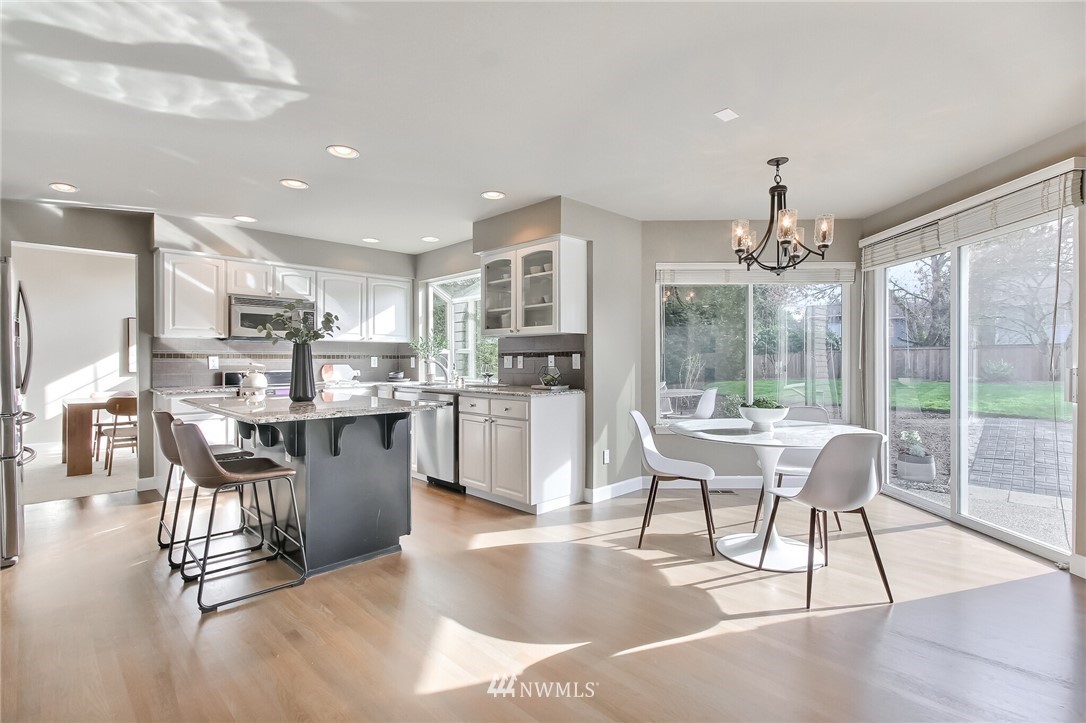 4405 Northeast 7th Street Renton, WA 98059 - Photo 13 of 27 a living room with stainless steel appliances kitchen island granite countertop a table chairs and a view of living room