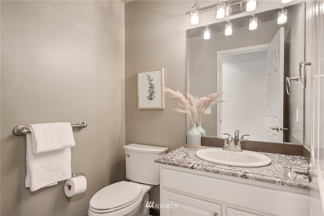 4405 Northeast 7th Street Renton, WA 98059 - Photo 17 of 27 a bathroom with a granite countertop toilet sink mirror and vanity
