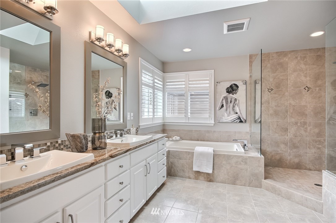 4405 Northeast 7th Street Renton, WA 98059 - Photo 20 of 27 a spacious bathroom with a double vanity sink a mirror a bathtub and next to a window