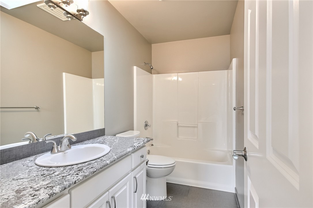 4405 Northeast 7th Street Renton, WA 98059 - Photo 21 of 27 a bathroom with a granite countertop sink toilet and shower