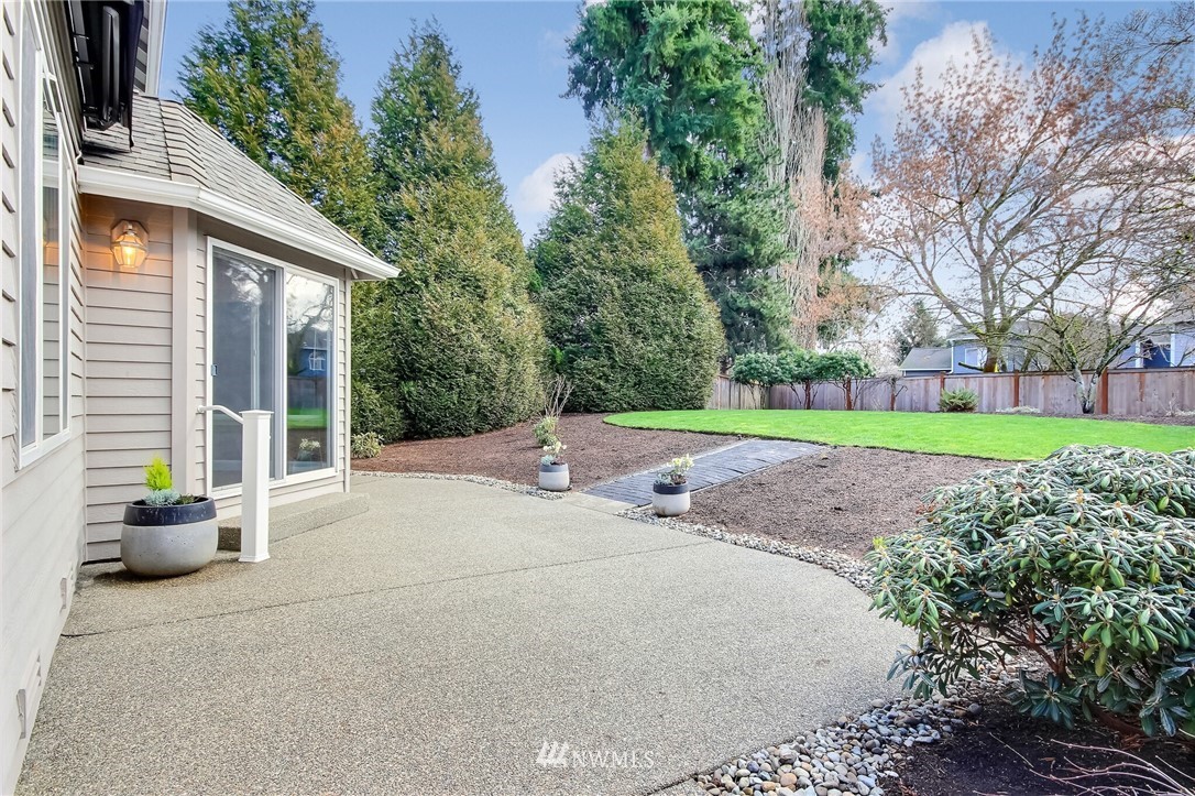 4405 Northeast 7th Street Renton, WA 98059 - Photo 25 of 27 a backyard of a house with table and chairs plants and large trees