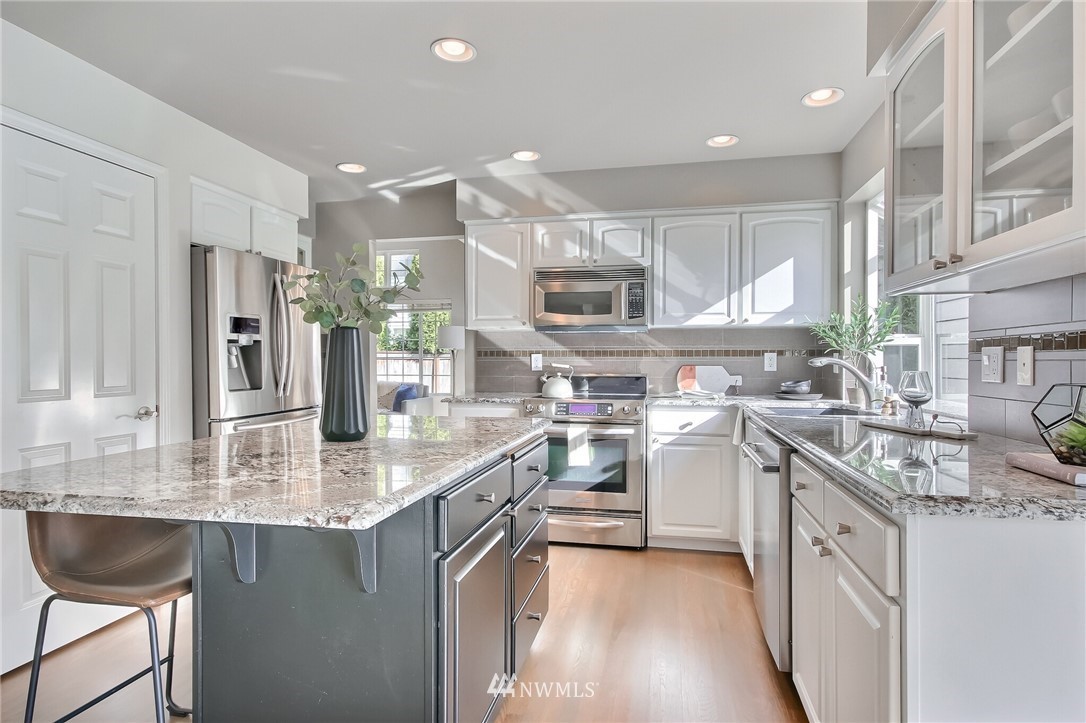 4405 Northeast 7th Street Renton, WA 98059 - Photo 9 of 27 a kitchen with stainless steel appliances granite countertop a sink stove and refrigerator