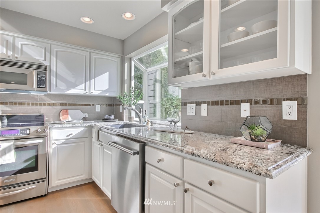 4405 Northeast 7th Street Renton, WA 98059 - Photo 10 of 27 a kitchen with stainless steel appliances granite countertop a sink stove and cabinets