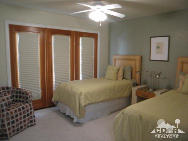 293 Serena Drive Palm Desert, CA 92260 - Photo 11 of 14 a bedroom with two beds and a chandelier