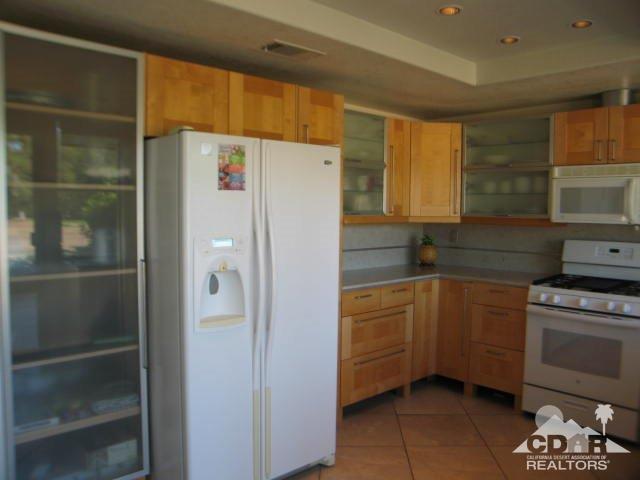 293 Serena Drive Palm Desert, CA 92260 - Photo 8 of 14 a kitchen with a refrigerator a stove and cabinets