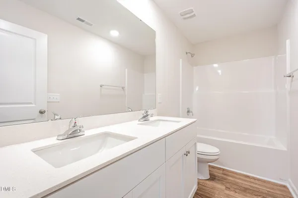 a bathroom with a sink double vanity granite toilet tub and shower