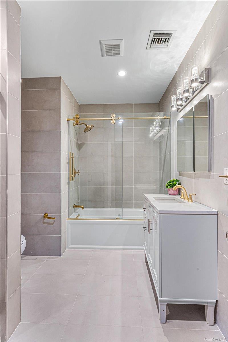 952 Cedar Swamp Road Glen Head, NY 11545 - Photo 29 of 50 a bathroom with a tub a sink and mirror