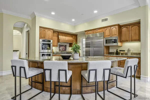 a kitchen with stainless steel appliances granite countertop a stove a sink dishwasher a dining table and chairs