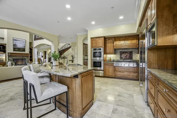 a kitchen with kitchen island a large counter top space a sink stainless steel appliances and cabinets