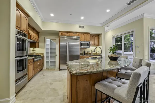 a kitchen with stainless steel appliances granite countertop a sink refrigerator and cabinets