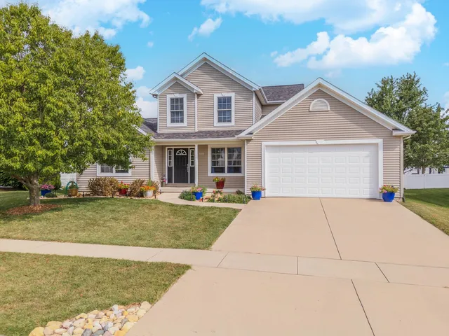 a front view of a house with a yard and trees