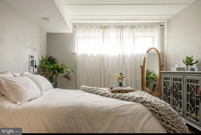 a bedroom with a bed table and a window