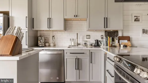 a kitchen with appliances a sink and cabinets