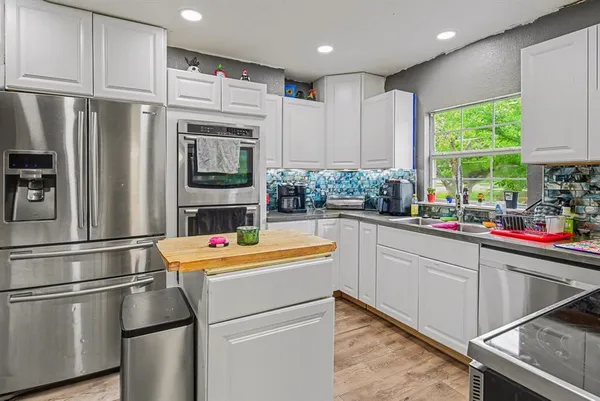 a kitchen with stainless steel appliances a refrigerator sink and cabinets