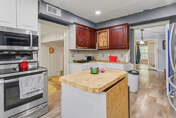 a kitchen with a refrigerator a stove and a cabinets