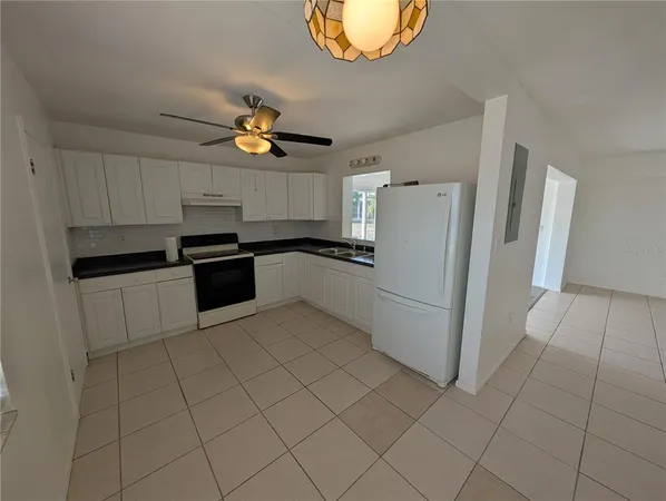a white refrigerator freezer and a stove sitting inside of a kitchen