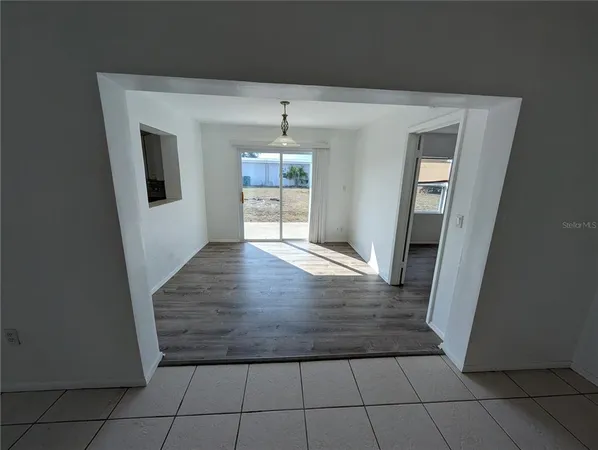 a view of a livingroom with wooden floor a ceiling fan and windows