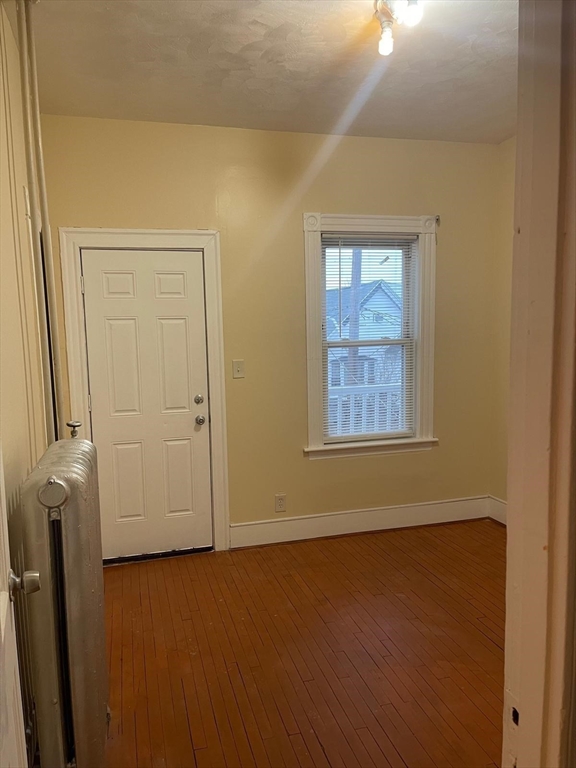 39 Magnolia Street, Unit 2 Malden, MA 02148 - Photo 13 of 15 an empty room with wooden floor and windows