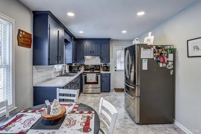 a kitchen with stainless steel appliances granite countertop a refrigerator sink and stove