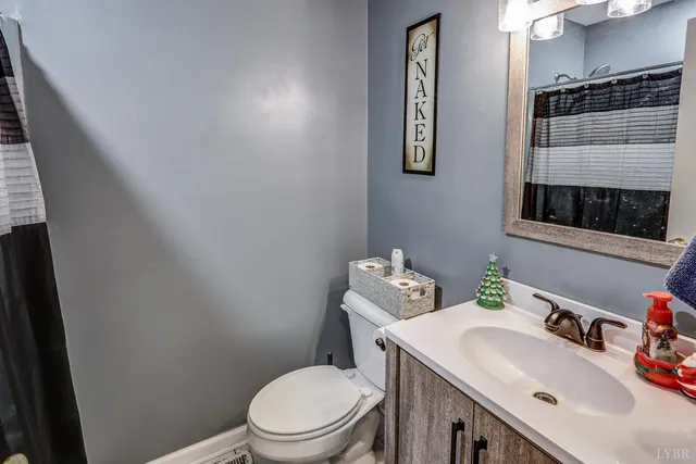 a bathroom with a sink vanity mirror and toilet