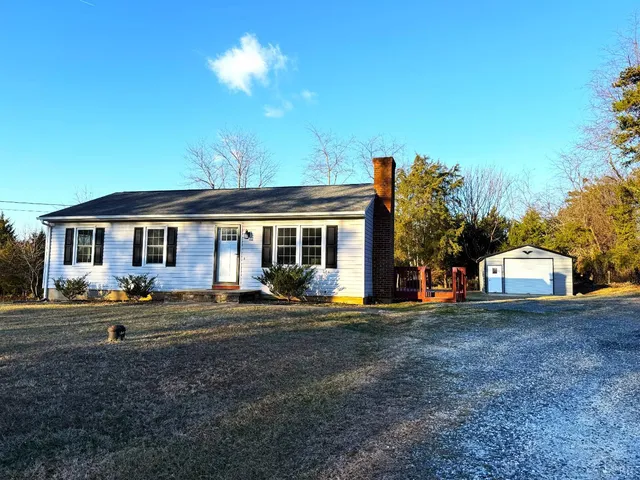 a backyard of a house with barbeque oven table and chairs