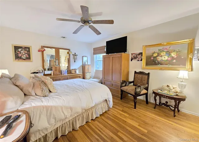 a bedroom with a bed a couch and a flat screen tv