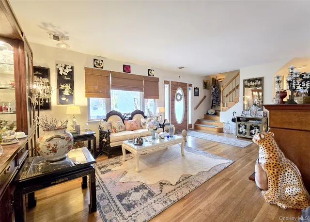 a living room with furniture large window and wooden floor